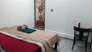 a bed in a room with a table and a chair at MistyKera in Vattavada