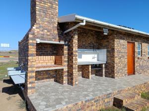 a brick building with a patio with a grill at Malkop Sea View Resort in Lambertʼs Bay