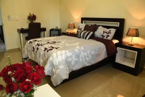 a bedroom with a bed with red roses on it at Hostal San Francisco de Asis in Santo Domingo