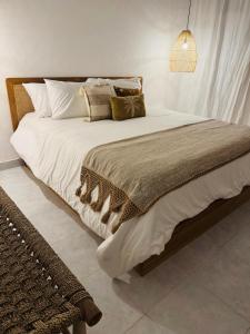 een slaapkamer met een groot bed met witte lakens en kussens bij Gypsea Rest Villa in Nusa Lembongan