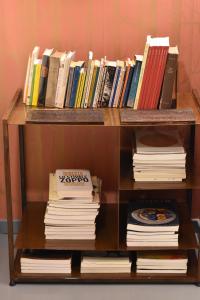 a book shelf filled with books and a pile of books at Ca' Monteggia Guest House in Milan