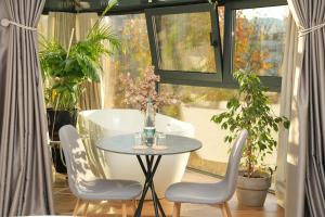 a table and chairs in a room with a window at Moonlight Apartments Tirana in Tirana