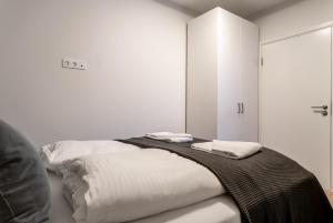 a white room with a bed with two towels on it at EIR Apartments by Heimaleiga in Reykjavík