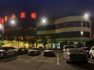 a parking lot with cars parked in front of a building at Jiangsu Cuipingshan Hotel in Jiangning
