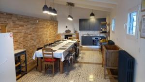 een keuken met een tafel met stoelen en een bakstenen muur bij El Romazal in Nava de la Asunción
