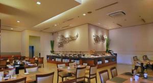 a restaurant with wooden tables and chairs and a bar at PARK HOTEL Cawang Jakarta in Jakarta