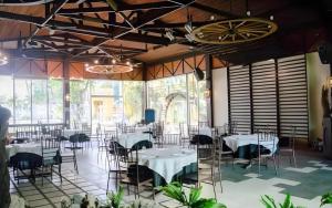 Un comedor con mesas y sillas y ventanas. en Country Village Hotel, en Carmen