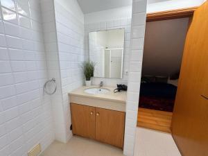 a bathroom with a sink and a mirror at Top floor Marina Duplex in Vila Franca do Campo +19 photos