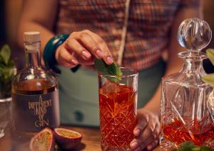 a person is stirring a drink in a glass at Banks Mansion - Boutique Hotel in Amsterdam