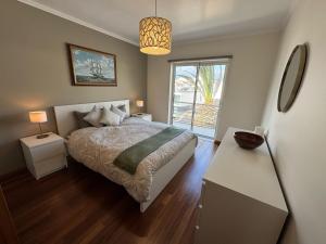a bedroom with a bed and a large window at Top floor Marina Duplex in Vila Franca do Campo