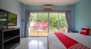 1 dormitorio con 1 cama y ventana grande con balcón en OYO 384 Ban Sabaidee, en Ban Maen