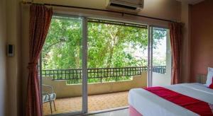 Un dormitorio con balcón con cama y ventana grande. en OYO 384 Ban Sabaidee, en Ban Maen 86 fotos más