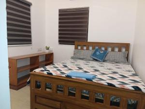 een slaapkamer met een houten bed en een bureau bij White coral beach home in Alleppey