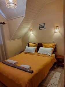 una camera da letto con un grande letto con lenzuola gialle di La Maison Betsileo a Fianarantsoa