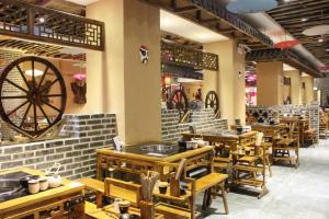 a restaurant with wooden tables and chairs and a wheel at 7 Days Inn Weihai High-Speed Railway & Bus Station in Weihai