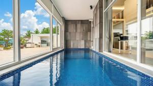 una piscina a sfioro in una casa con finestre di Goseong Belloci Kids Poolivilla a Goseong Altre 4 foto