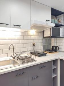 Una cocina blanca con fregadero y encimera. en Homey Edessa Loft, en Édessa