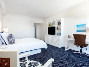 a bedroom with a bed and a tv and a desk at Oceans Edge Key West in Key West