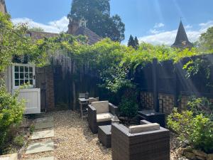 een tuin met een stoel en een hek bij The Cottage in Fernhurst +9 foto's