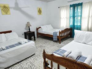 een woonkamer met twee bedden en een bank bij Jardín Escondido in La Libertad +33 foto's