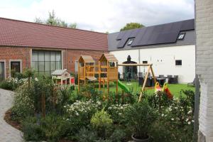 a garden with a playground and a building at Hof van Vlaanderen in Zwalm
