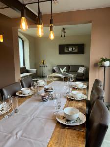 a dining room with a table with plates and glasses at Hof van Vlaanderen in Zwalm