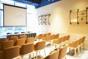 a lecture room with chairs and a projection screen at Hotel COZi·Wetland in Hong Kong