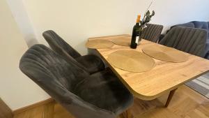 un tavolo con una sedia in pelle nera e una bottiglia di vino di Sky View - stan na dan Banja Luka a Banja Luka Altre 8 foto