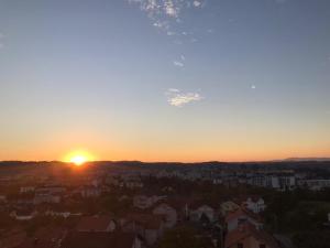 un tramonto su una città con case ed edifici di Sky View - stan na dan Banja Luka a Banja Luka
