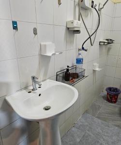 west water hostel في فانغ فينغ: حوض أبيض في حمام من البلاط الأبيض +24 صورة