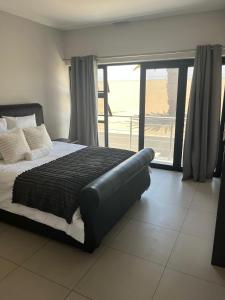 een slaapkamer met een groot bed en een balkon bij Modern Getaway in Rand Rifles