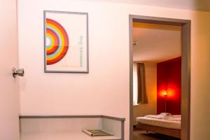 Zimmer mit einem Spiegel und einem Bild an der Wand in der Unterkunft Hessenland Hotel Kassel Innenstadt by Stay Awesome in Kassel + 55 Fotos