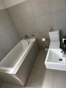 een badkamer met een bad, een toilet en een wastafel bij Modern Getaway in Rand Rifles