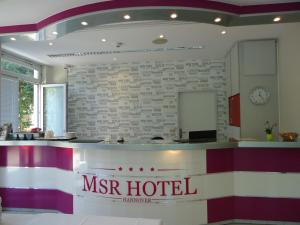 a lobby of a mhr hotel with a clock on the wall at MSR Hotel Hannover in Hannover