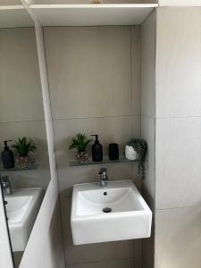 een badkamer met een witte wastafel en een spiegel bij Modern Getaway in Rand Rifles