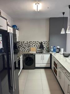 een keuken met wasmachine en droger bij Modern Getaway in Rand Rifles
