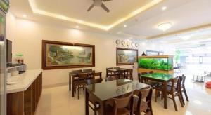 a living room with tables and chairs and a fishtank at Luxury Airport Hotel & Spa in Phu Lo Dong