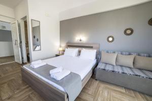 a bedroom with a large bed and a couch at Dream Studios in Stavros +27 photos
