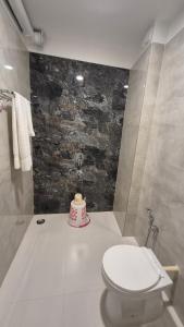 Un baño con inodoro y un pastel en el suelo. en Hotel City Palace, en Bhagalpur