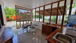 a kitchen with a sink and a table and some windows at Molmol Cafe in Larena