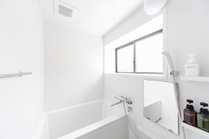 uma casa de banho com uma banheira e um espelho. em Best Hotel em Tóquio
