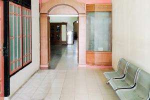 an empty hallway with two benches in a building at Nirina Homestay Pringsewu Mitra RedDoorz in Margakaya
