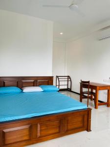 a bedroom with a bed with blue sheets and a table at Dondra OceanLight Villa in Gandara East +55 photos
