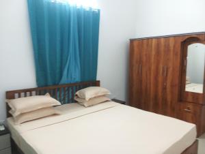 Un dormitorio con una cama con espejo y una cortina azul. en The Tourist Street, en Cavelossim 13 fotos más