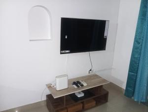 Una sala de estar con un televisor en la pared. en The Tourist Street, en Cavelossim