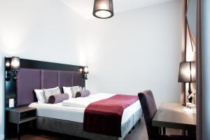 a bedroom with a bed and a desk and a table at Fair Hotel Europaallee in Frankfurt