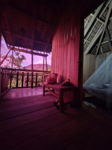 a room with a bench on a wooden porch at Yasur Backpackers Bungalow & Tree House in Tanna Island