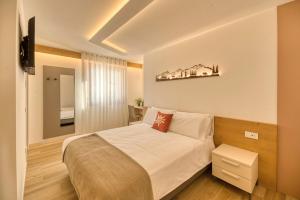 een slaapkamer met een groot bed en een televisie bij La Corte Delle Dolomiti in Agordo