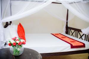 a bedroom with a bed with a vase of flowers on a table at The Cozy Villa in Ambalangoda +19 photos