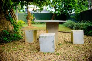 a concrete bench with two stone pillars in a park at The Cozy Villa in Ambalangoda